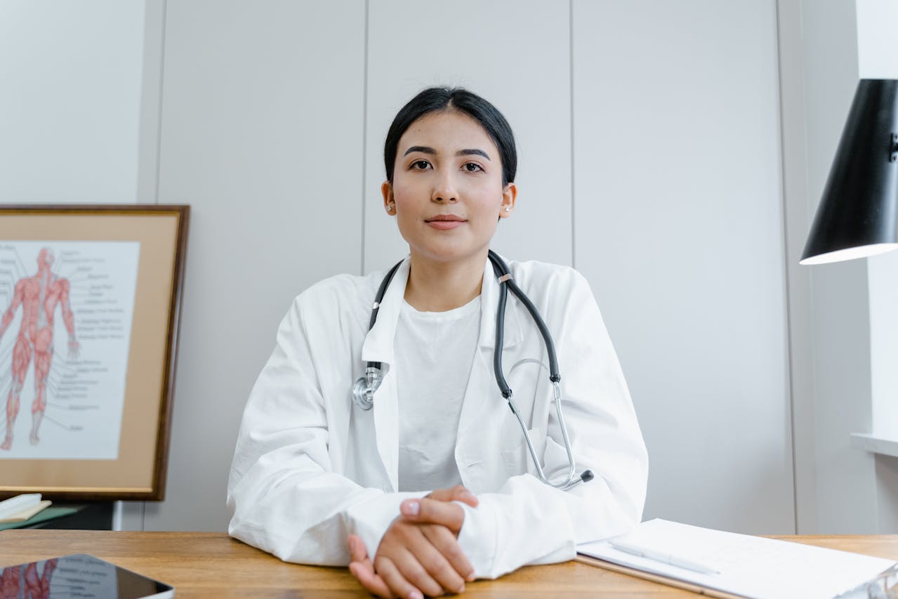 A doctor in a white coat, wearing a stethoscope.