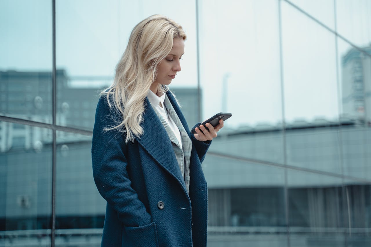 Woman in a Blue Coat Using Her Phone