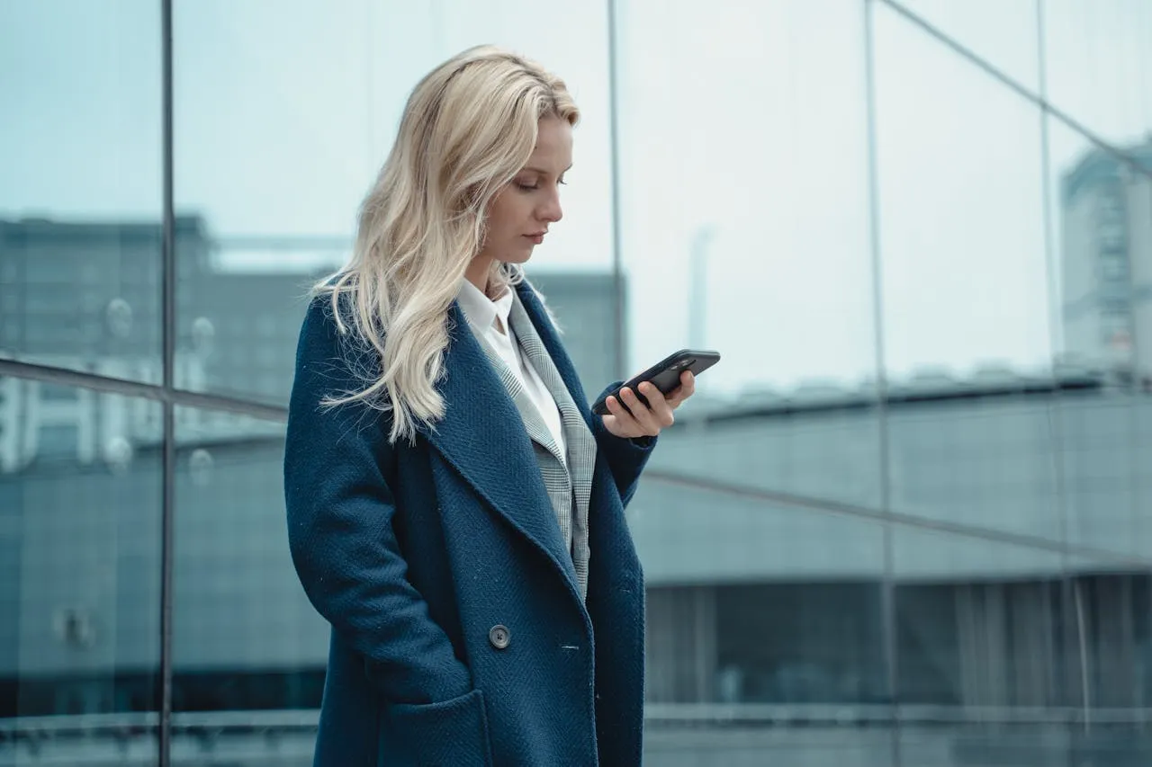 Woman in a Blue Coat Using Her Phone